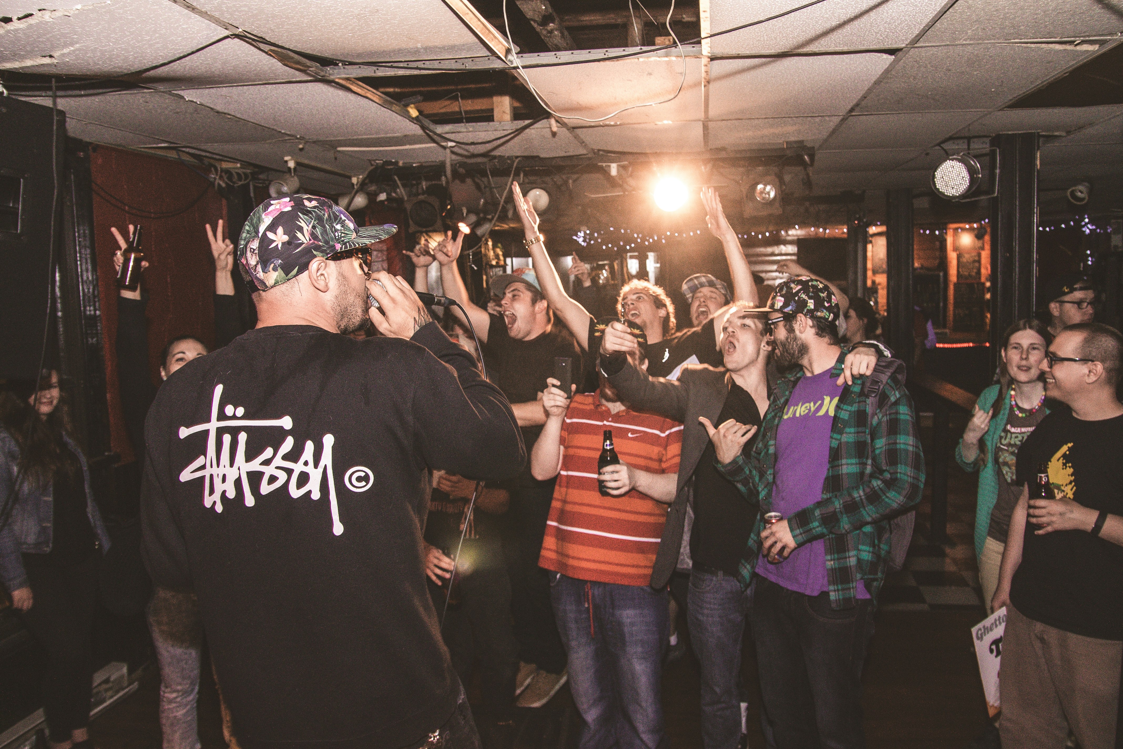 group of people standing and raising hands